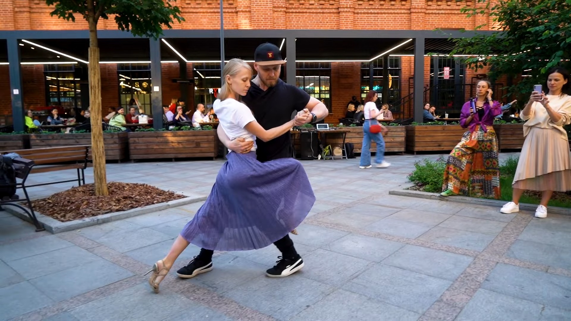 A couple in trendy clothes dance tango nuevo in the street