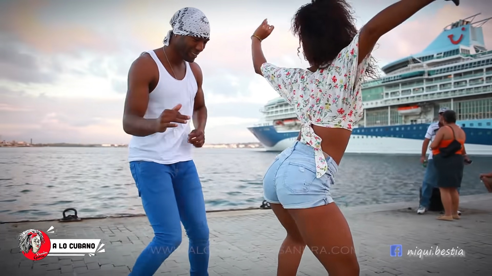 Cuban man and women dancing timba near the sea