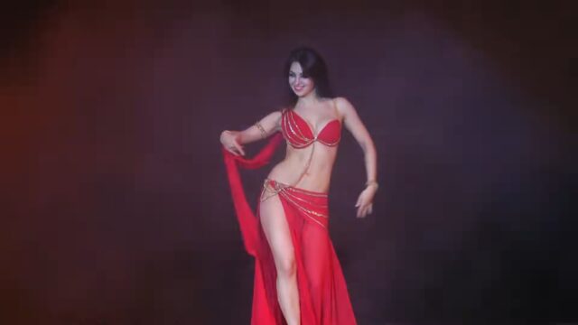 Beautiful woman in red costume belly dancing on the stage