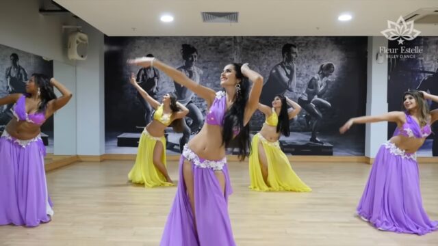 Women of various ethnicities belly dancing in the studio