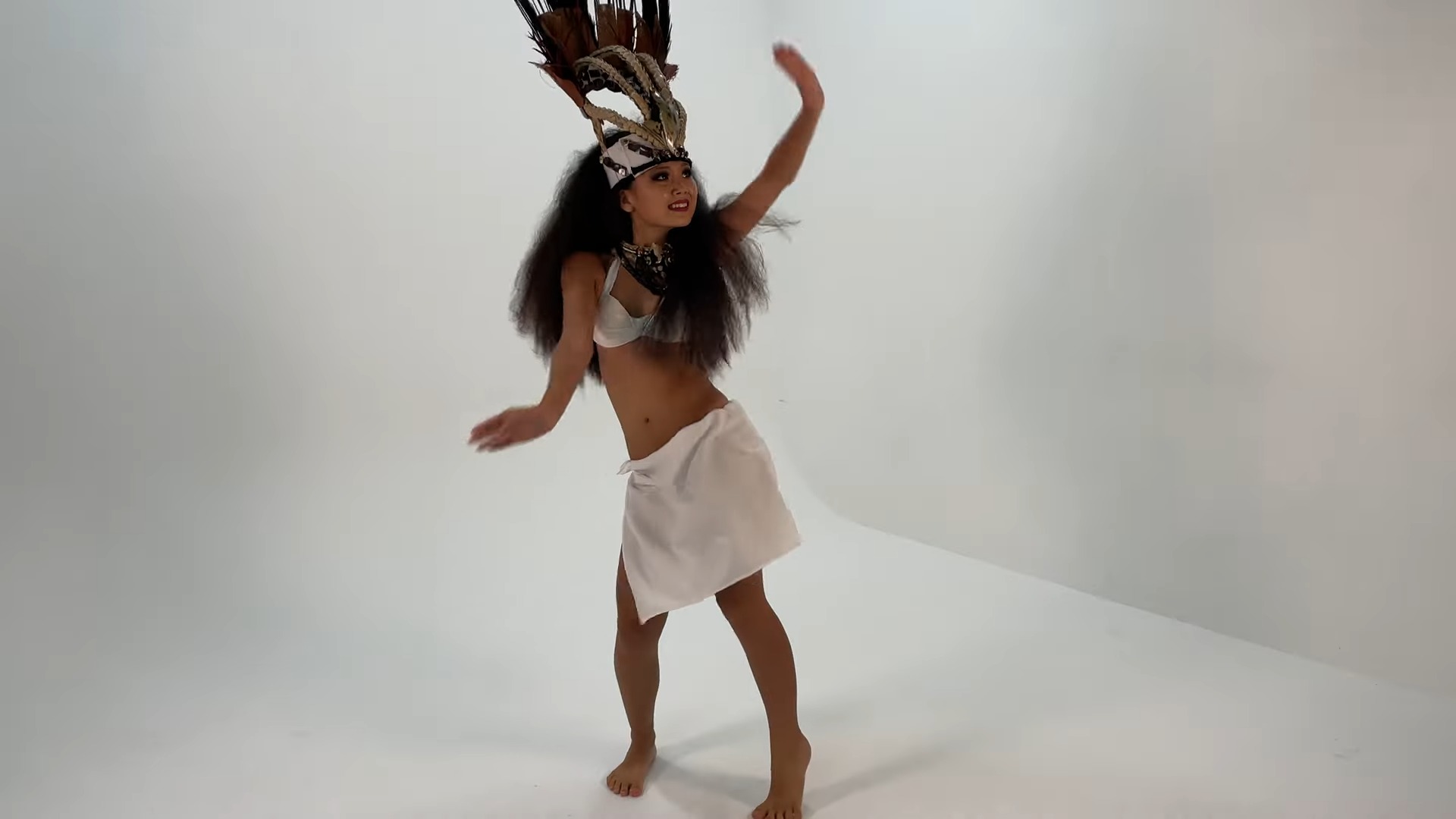 Teenage girl dancing Ori Tahiti (Tahitian Dance) in a white studo